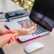 woman holding her wrist pain from using computer