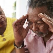 A man suffering from Alzheimer's disease is being comforted by a women.